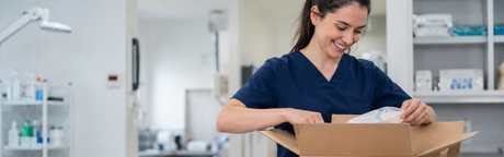 Vet nurse unpacking delivery box from Pioneer Veterinary Products.